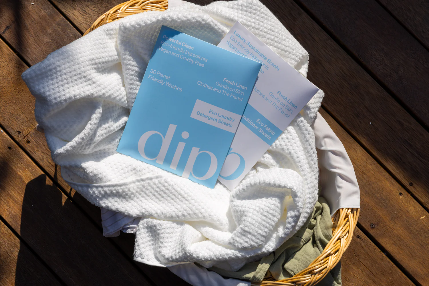 Dip laundry detergent sheets on a basket of fresh white towels